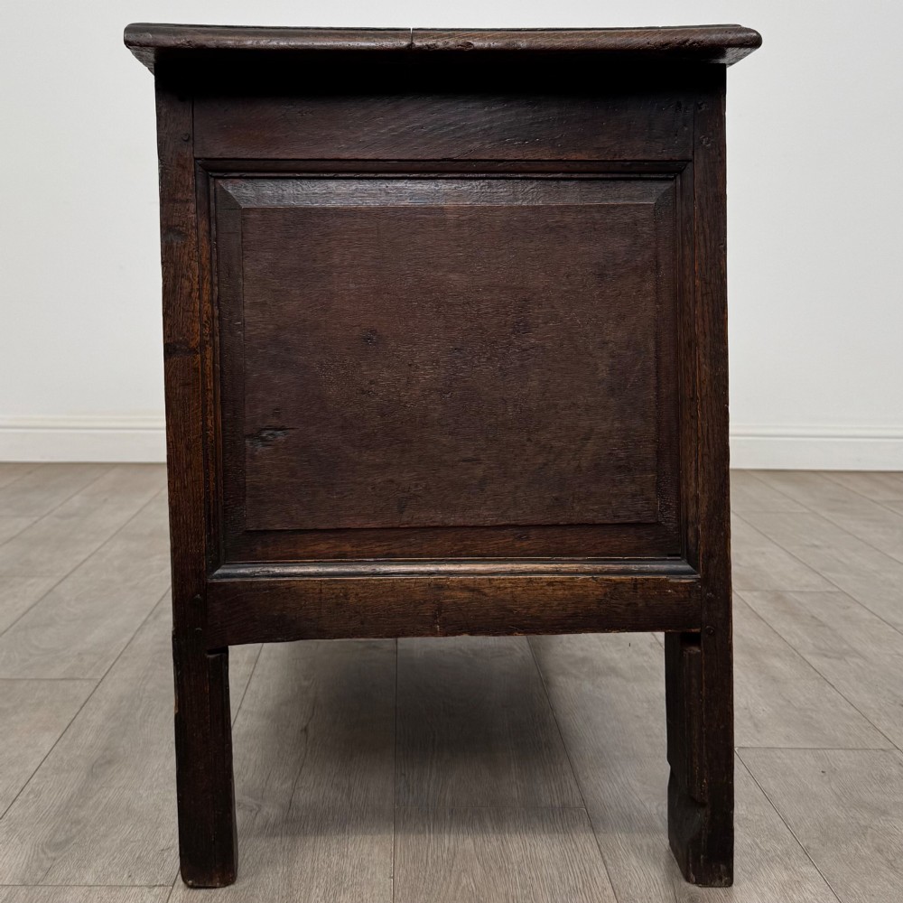 An 18th-century Georgian golden oak coffer featuring three raised panel front section and a carved top rail dated 1723 with initials D H. View VII
