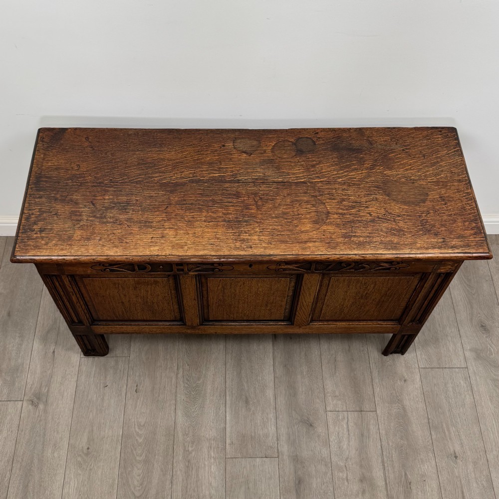 An 18th-century Georgian golden oak coffer featuring three raised panel front section and a carved top rail dated 1723 with initials D H. View IX