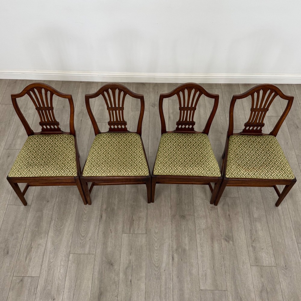 A set of four 18th-century Georgian mahogany dining chairs featuring pierced vertical back splats and green patterned drop-in seats. View VII