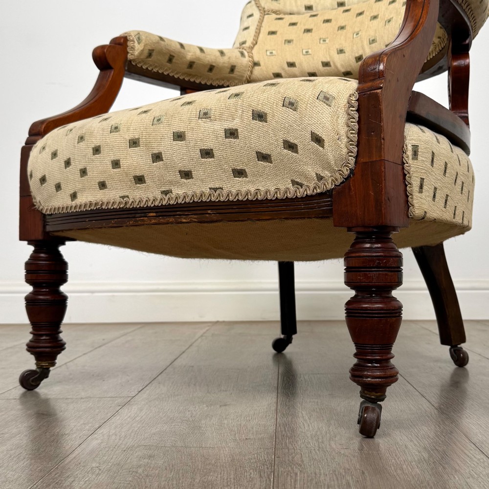 A pair of Edwardian mahogany tub chairs upholstered in a patterned cream fabric with turned front legs on castors. View XII