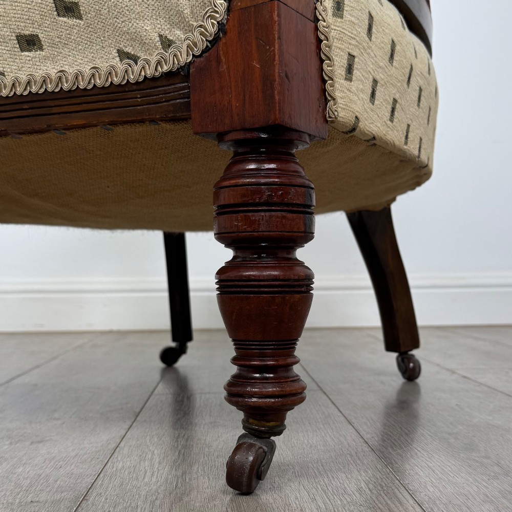 A pair of Edwardian mahogany tub chairs upholstered in a patterned cream fabric with turned front legs on castors. View XIII