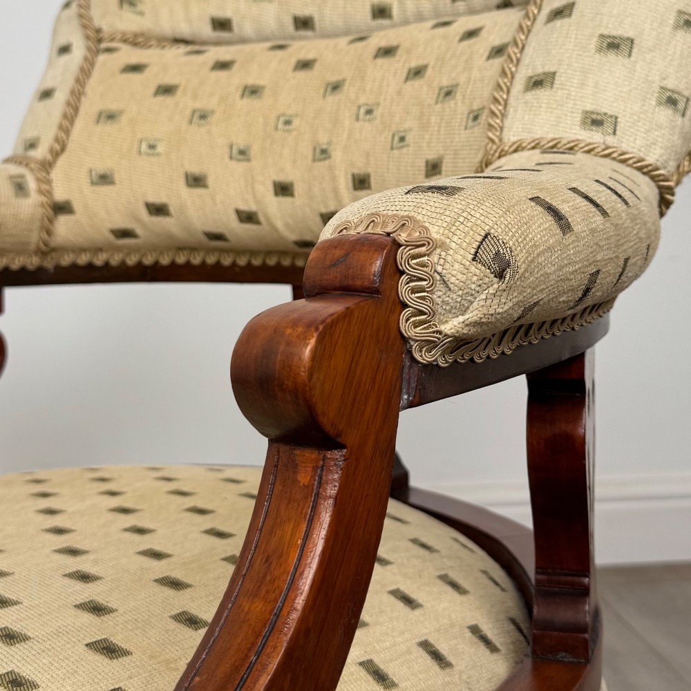 A pair of Edwardian mahogany tub chairs upholstered in a patterned cream fabric with turned front legs on castors. View XIV