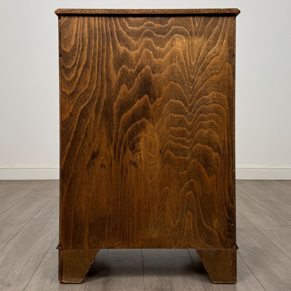 A tall 20th-century yew wood chest of drawers featuring two short drawers over four long graduated drawers with brass drop handles and bracket feet. View V