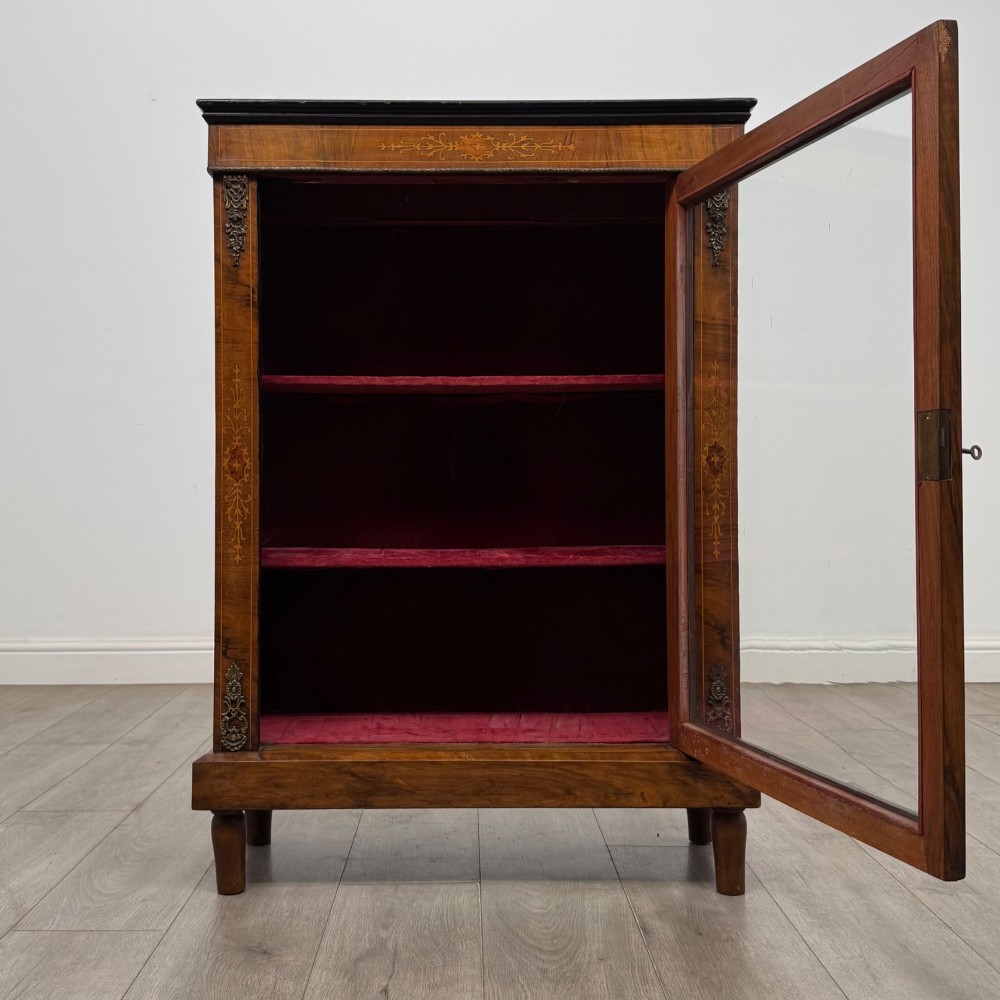 A 19th-century Victorian walnut pier cabinet featuring floral marquetry inlay, gilt brass mounts, and a single glazed door revealing lined interior shelves. View II