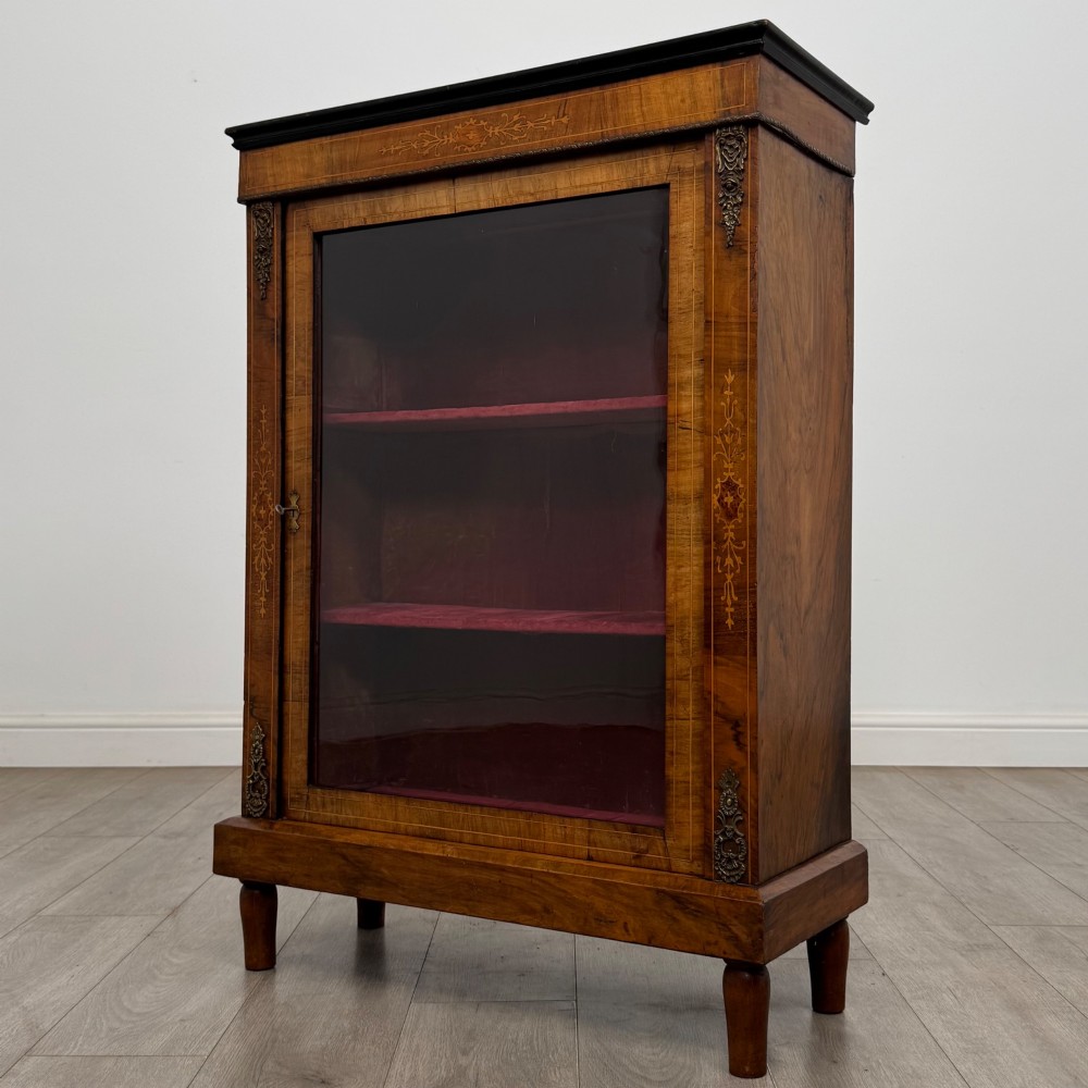 A 19th-century Victorian walnut pier cabinet featuring floral marquetry inlay, gilt brass mounts, and a single glazed door revealing lined interior shelves. View III