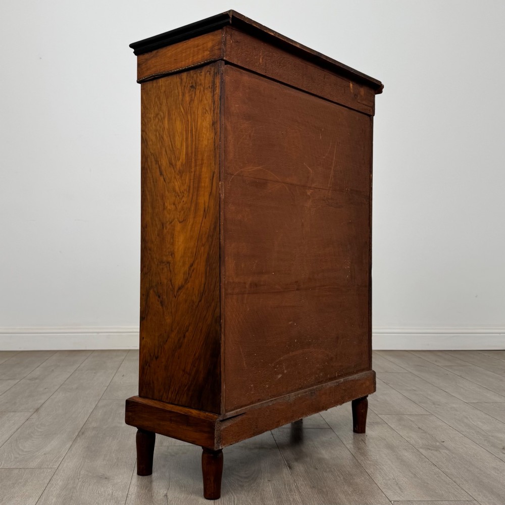 A 19th-century Victorian walnut pier cabinet featuring floral marquetry inlay, gilt brass mounts, and a single glazed door revealing lined interior shelves. View V