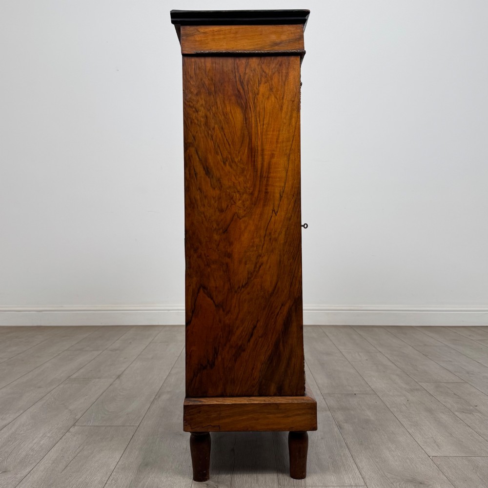 A 19th-century Victorian walnut pier cabinet featuring floral marquetry inlay, gilt brass mounts, and a single glazed door revealing lined interior shelves. View VIII