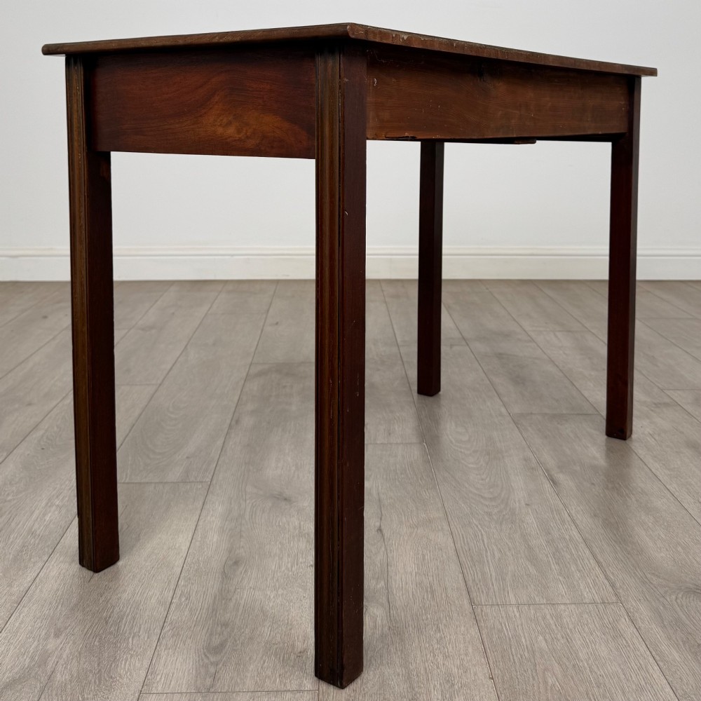 A 19th-century mahogany writing table with a curved serpentine front edge, two drawers with brass handles, and square legs. View IV
