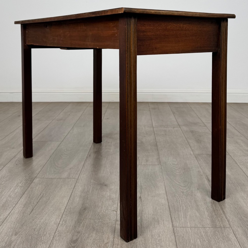 A 19th-century mahogany writing table with a curved serpentine front edge, two drawers with brass handles, and square legs. View VI