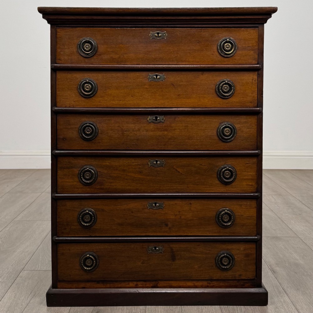 An antique Edwardian mahogany chest of drawers featuring six graduated drawers with round brass ring handles.