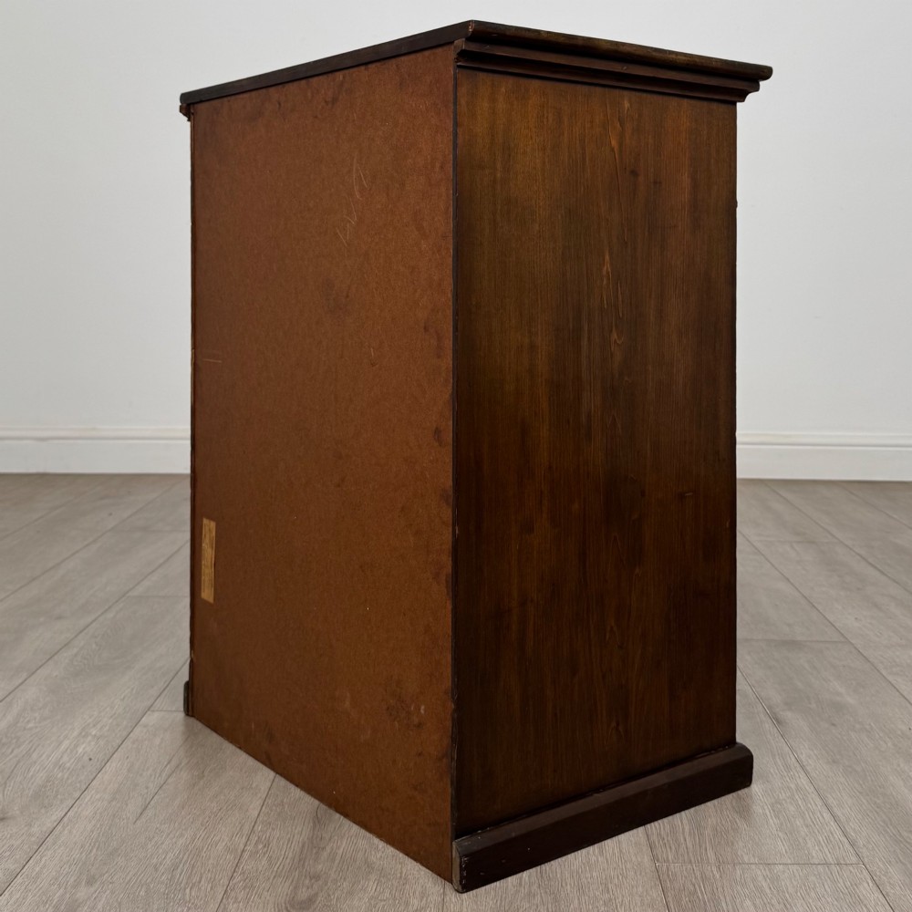 An antique Edwardian mahogany chest of drawers featuring six graduated drawers with round brass ring handles. View VI