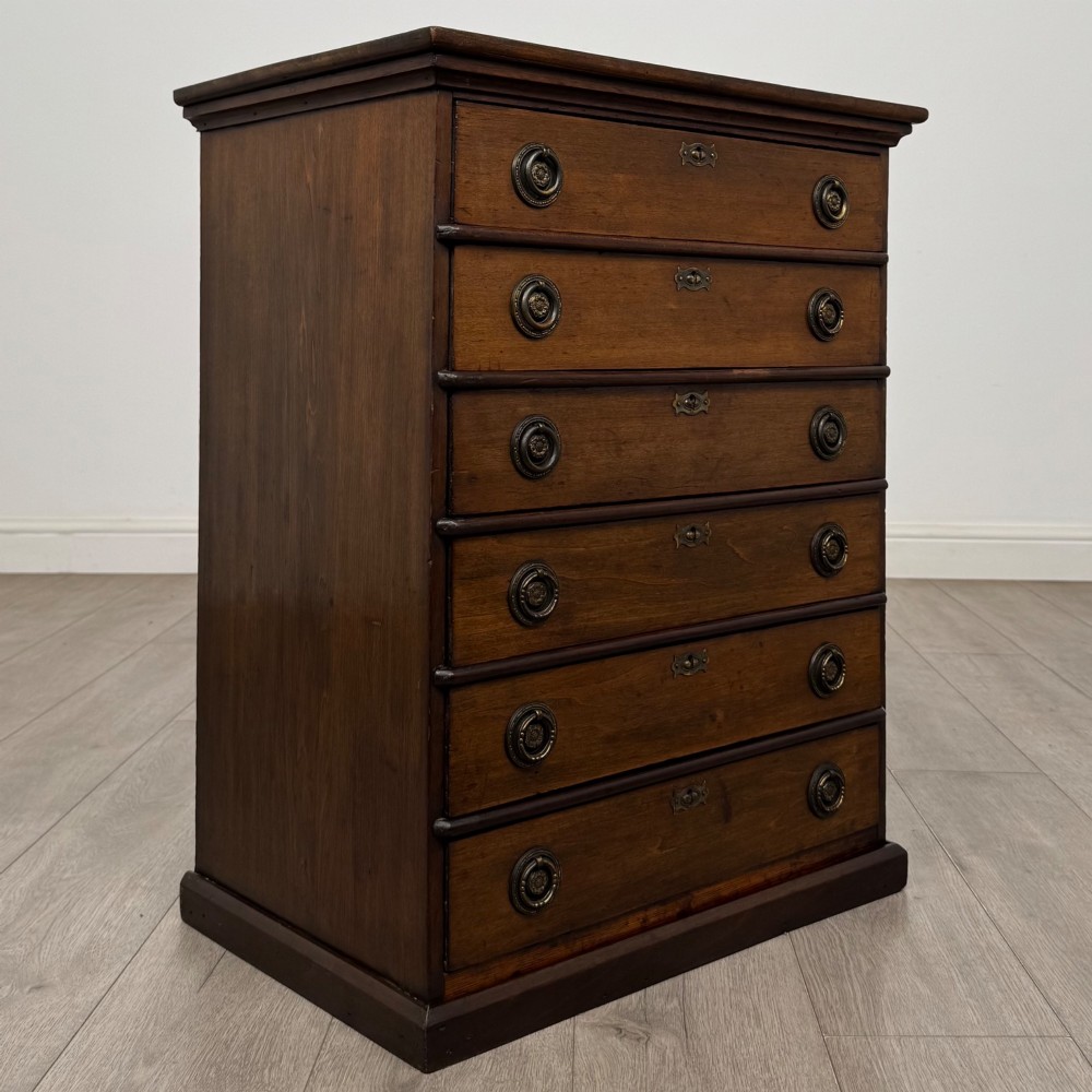 An antique Edwardian mahogany chest of drawers featuring six graduated drawers with round brass ring handles. View VIII