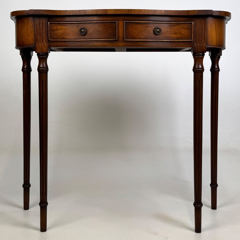 A slender 20th-century mahogany and burr walnut side table featuring two front drawers with brass ring handles and four fluted tapered legs.