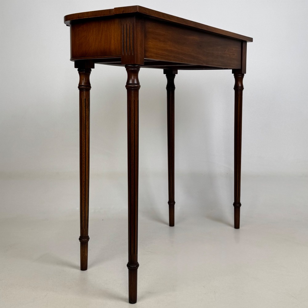 A slender 20th-century mahogany and burr walnut side table featuring two front drawers with brass ring handles and four fluted tapered legs. View IV