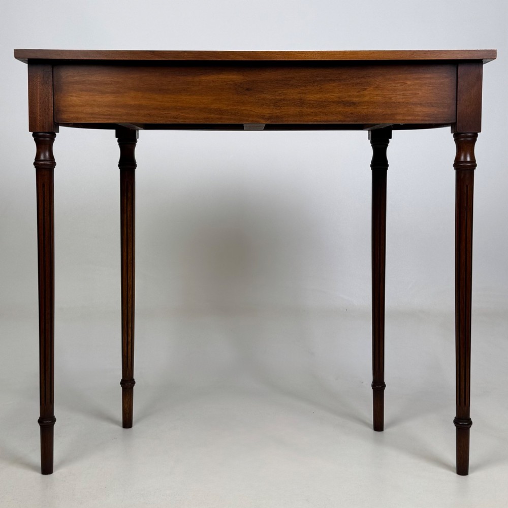 A slender 20th-century mahogany and burr walnut side table featuring two front drawers with brass ring handles and four fluted tapered legs. View V