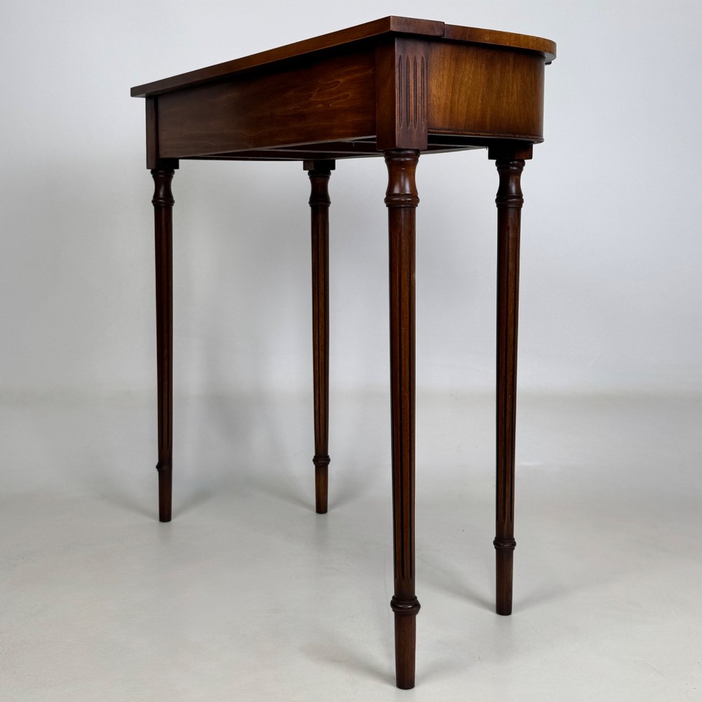 A slender 20th-century mahogany and burr walnut side table featuring two front drawers with brass ring handles and four fluted tapered legs. View VI