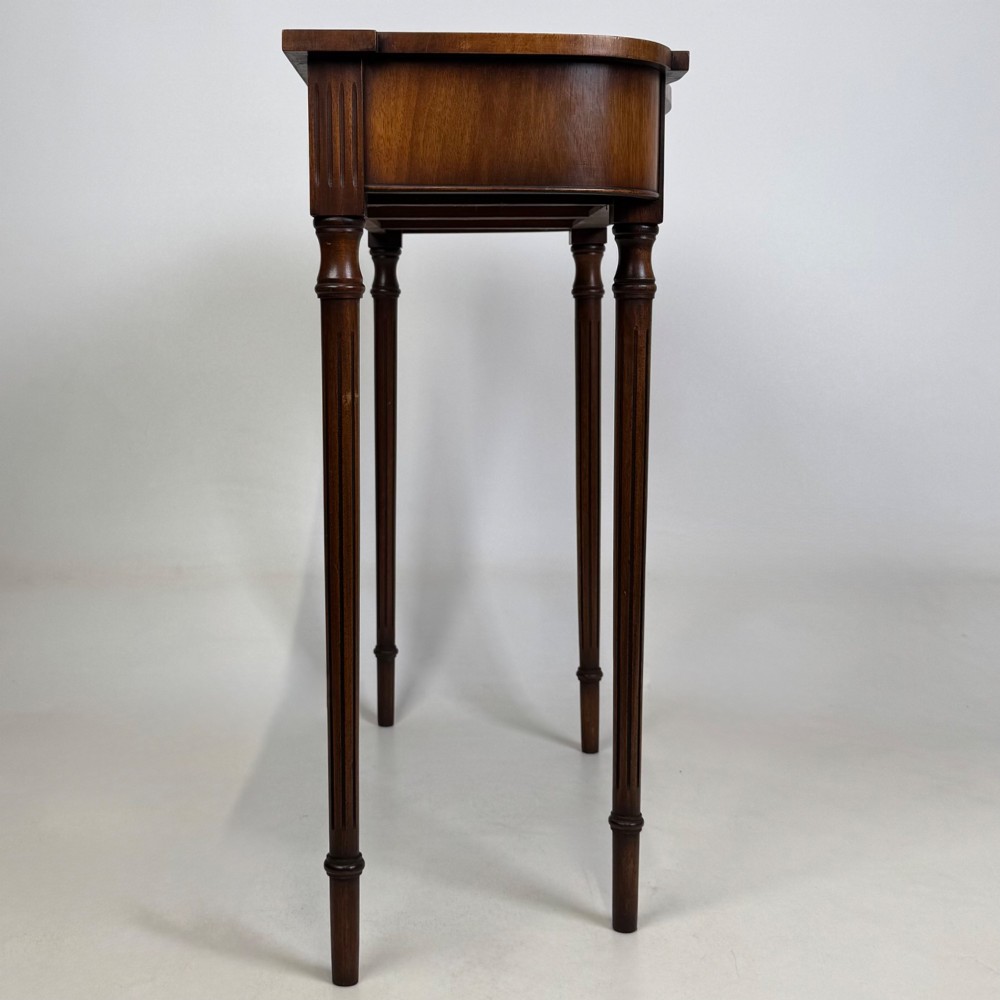 A slender 20th-century mahogany and burr walnut side table featuring two front drawers with brass ring handles and four fluted tapered legs. View VII