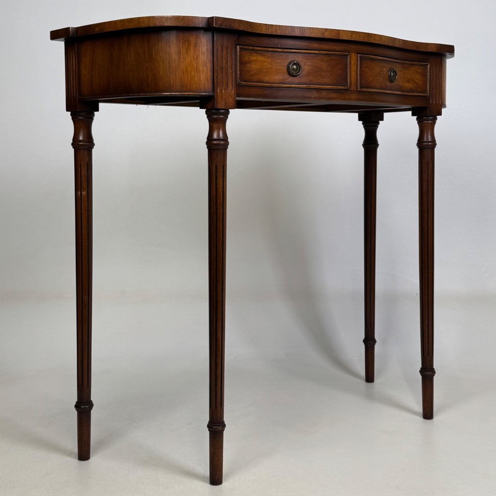 A slender 20th-century mahogany and burr walnut side table featuring two front drawers with brass ring handles and four fluted tapered legs. View VIII