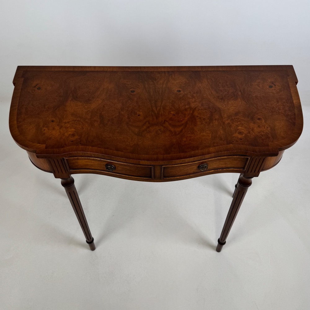 A slender 20th-century mahogany and burr walnut side table featuring two front drawers with brass ring handles and four fluted tapered legs. View X