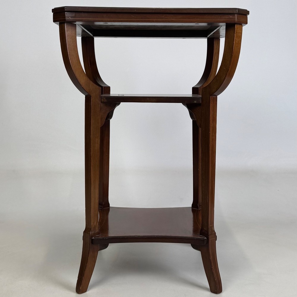 An Edwardian dark mahogany side table featuring a square top, sweeping curved leg supports, and two lower shelves. View II