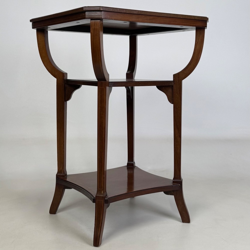 An Edwardian dark mahogany side table featuring a square top, sweeping curved leg supports, and two lower shelves. View III