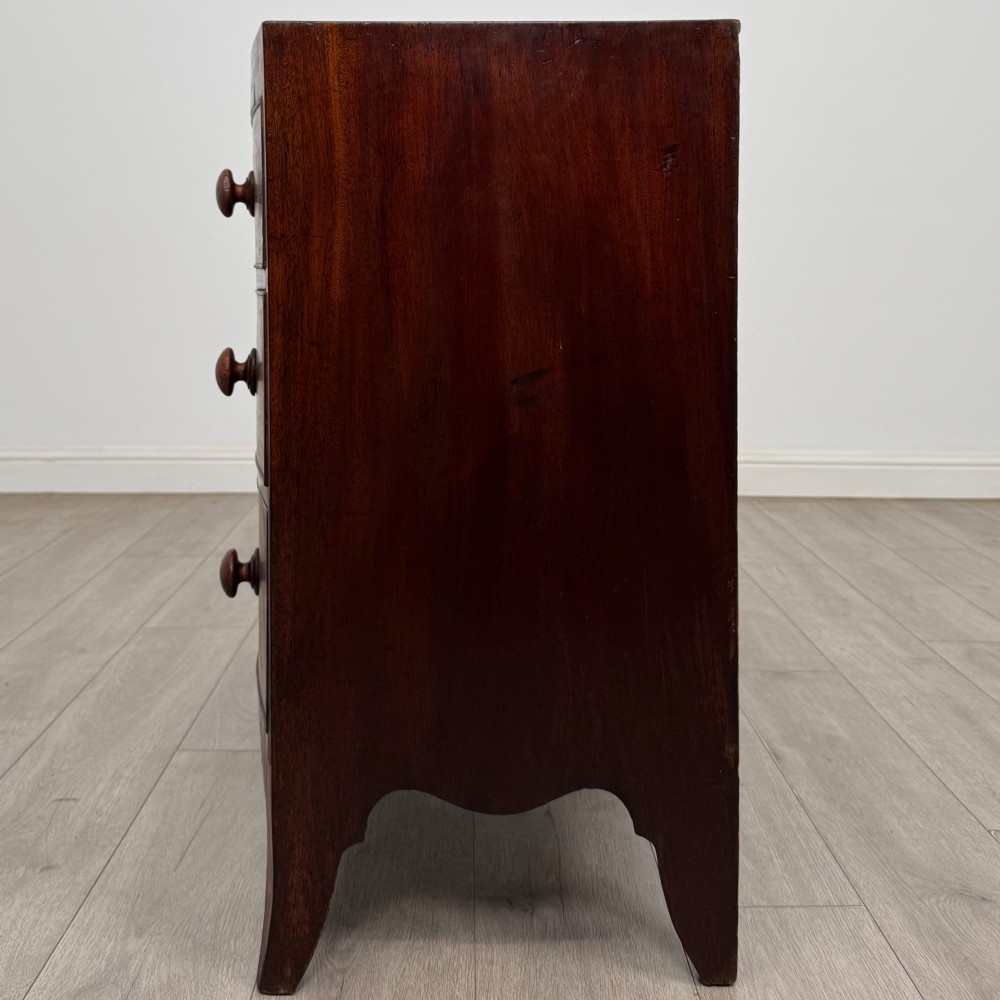 An 18th-century mahogany bow-front chest of drawers featuring three graduated drawers with turned wooden handles and splayed feet. View III