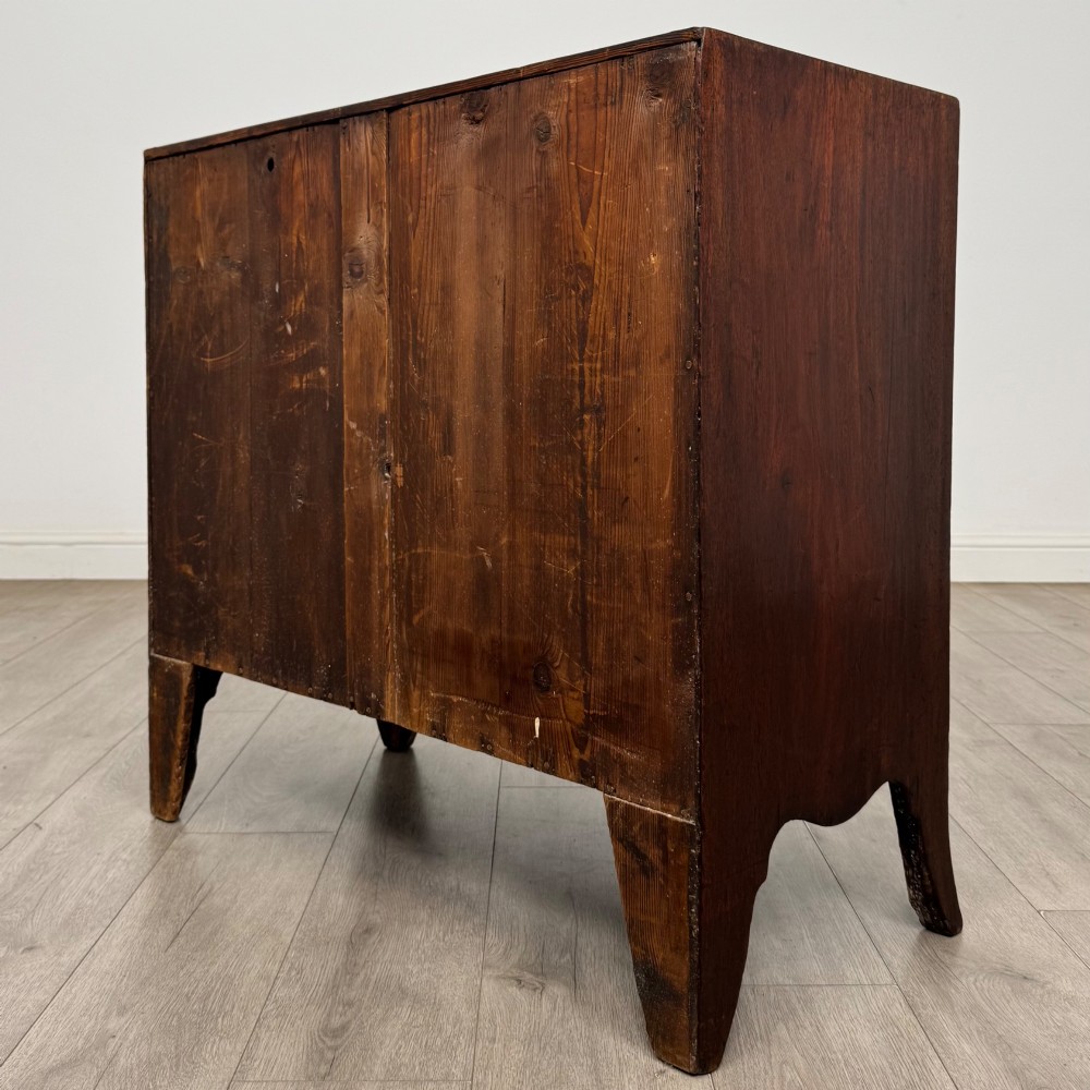 An 18th-century mahogany bow-front chest of drawers featuring three graduated drawers with turned wooden handles and splayed feet. View VI