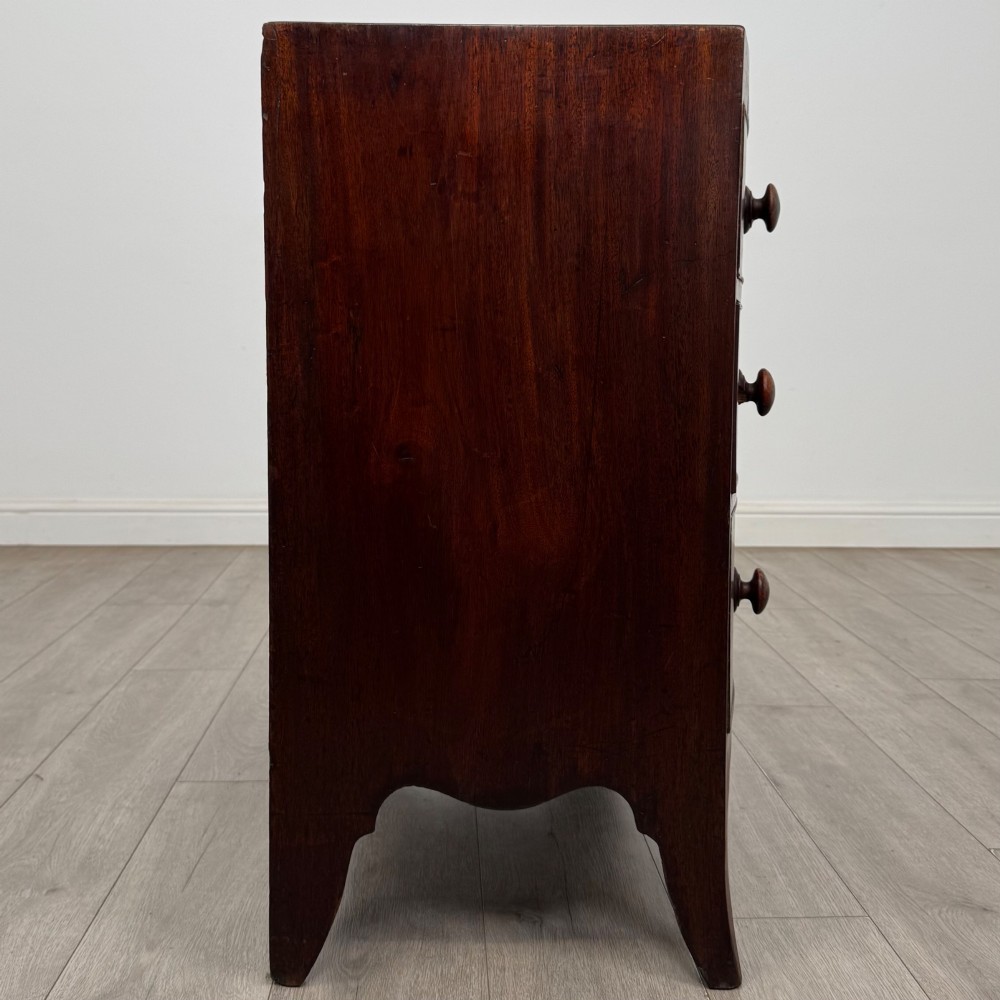 An 18th-century mahogany bow-front chest of drawers featuring three graduated drawers with turned wooden handles and splayed feet. View VII