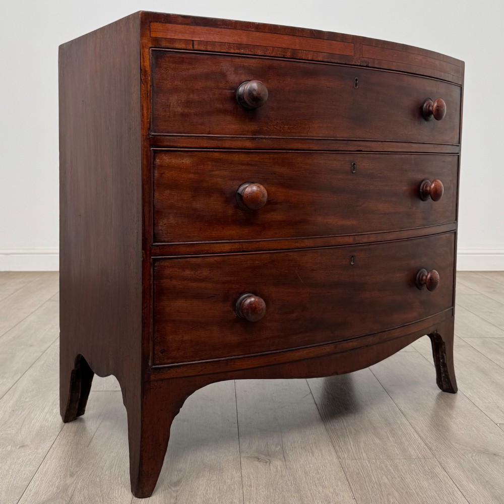 An 18th-century mahogany bow-front chest of drawers featuring three graduated drawers with turned wooden handles and splayed feet. View VIII