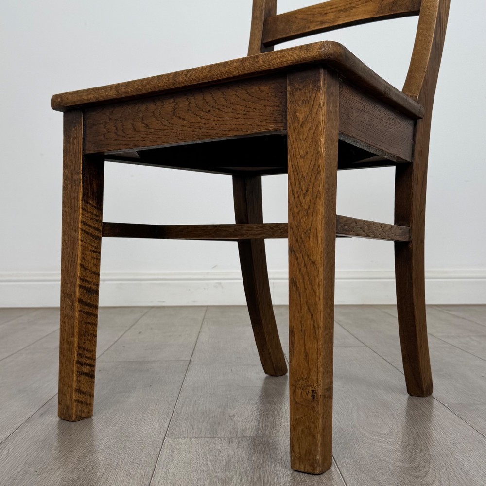 A set of six Victorian solid oak dining chairs featuring curved backrails, solid wooden seats, and square legs with stretchers. View V