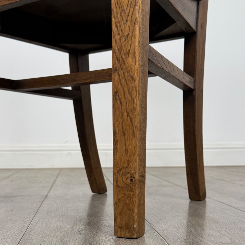 A set of six Victorian solid oak dining chairs featuring curved backrails, solid wooden seats, and square legs with stretchers. View VI