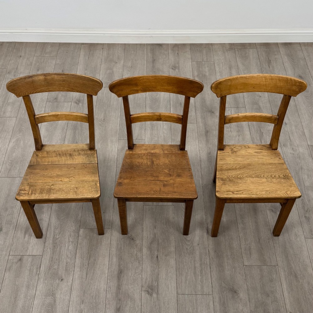 A set of six Victorian solid oak dining chairs featuring curved backrails, solid wooden seats, and square legs with stretchers. View VIII
