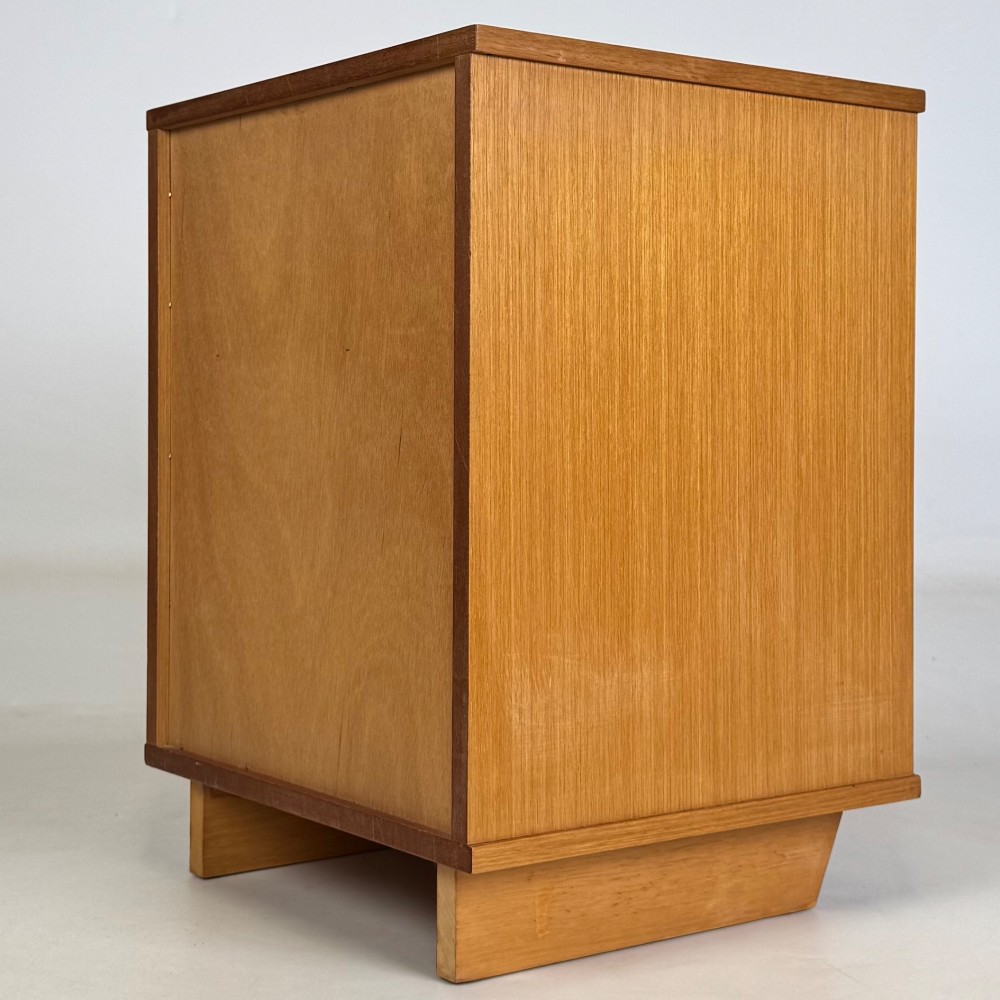 A pair of mid-century modern warm brown teak bedside cabinets featuring open upper shelf cubbies, lower cupboard doors with dark round wooden knobs, and low angled feet. View VIII