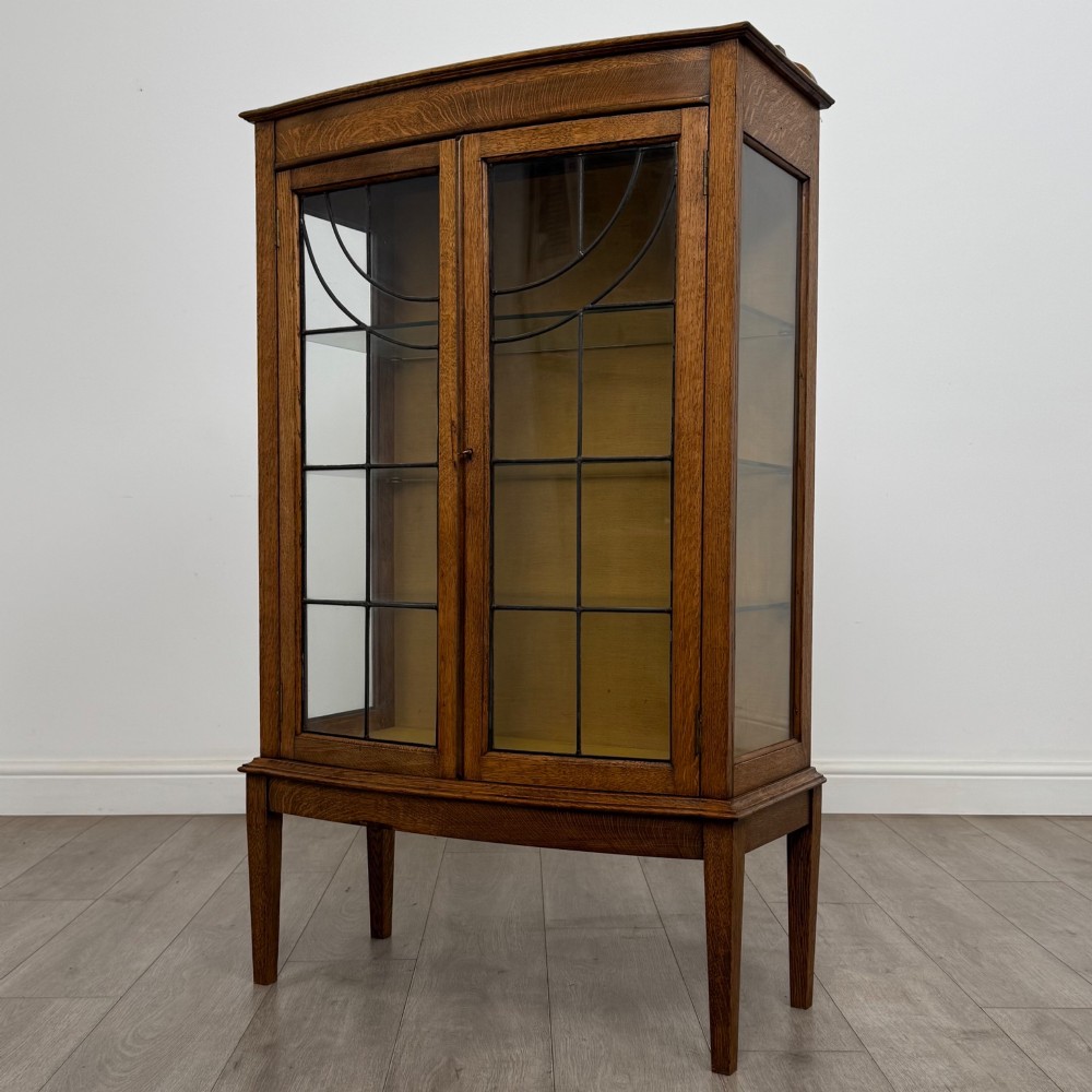 An Edwardian oak display cabinet with double leaded glass doors and square tapered legs. View III