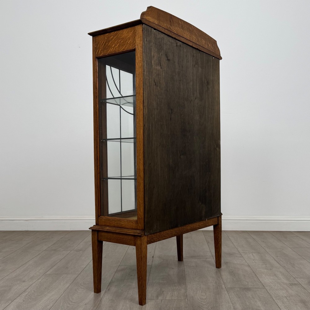 An Edwardian oak display cabinet with double leaded glass doors and square tapered legs. View V