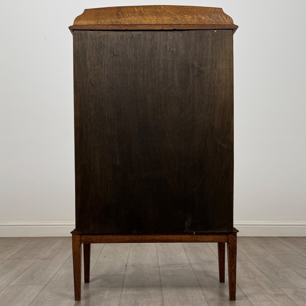An Edwardian oak display cabinet with double leaded glass doors and square tapered legs. View VI