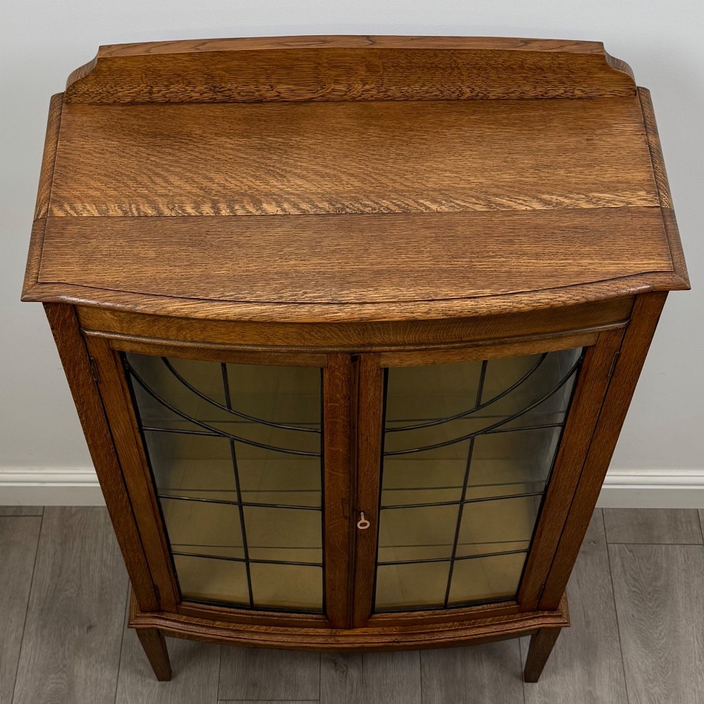 An Edwardian oak display cabinet with double leaded glass doors and square tapered legs. View X