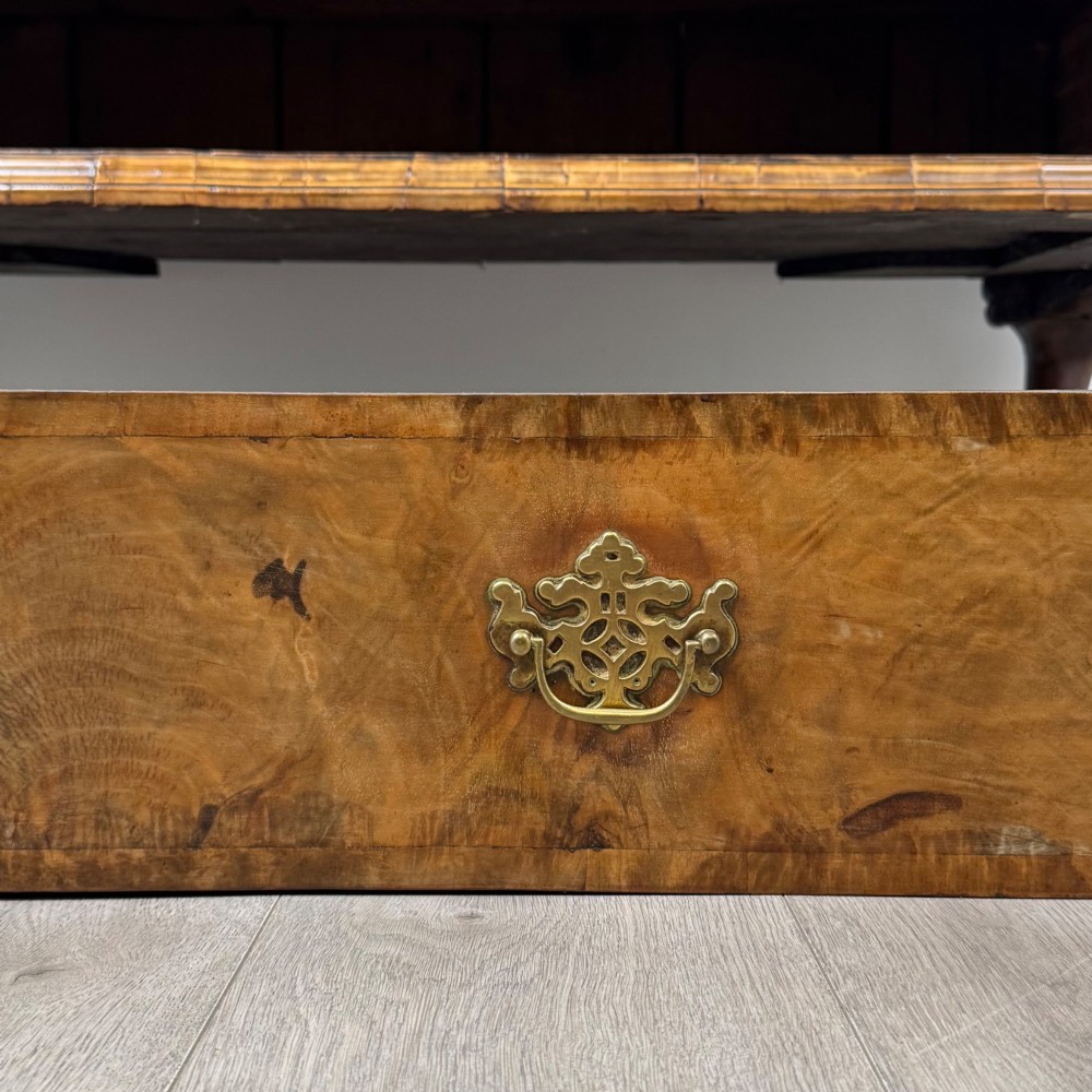 An 18th-century Queen Anne walnut chest of drawers featuring figured wood veneer, brass drop handles, and cabriole legs ending in pad feet. View XI