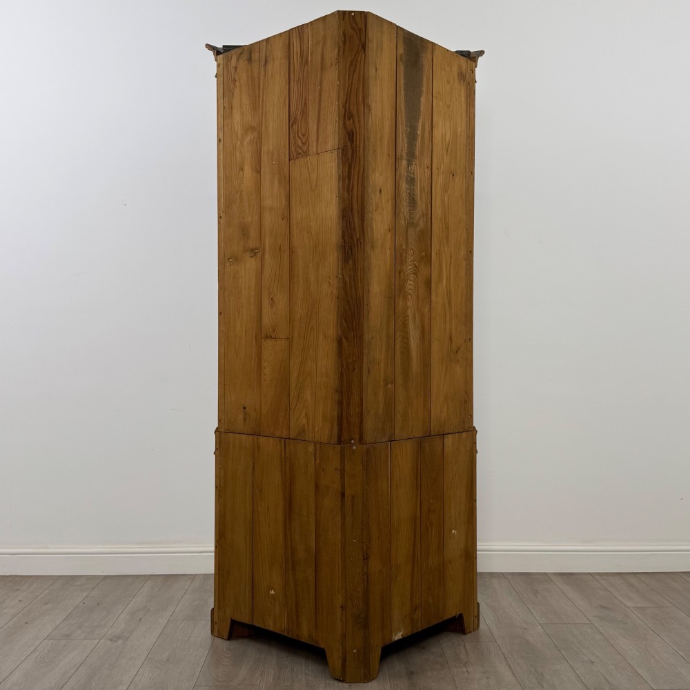 A tall dark oak Jacobean style corner cabinet featuring glazed display doors above lower cupboard doors with geometric fielded panelling. View IV