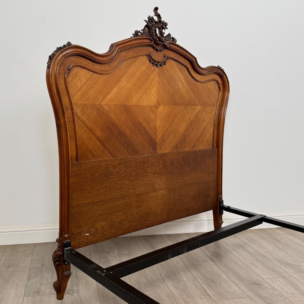 A 19th-century French walnut double bed featuring a carved crest headboard, matching footboard with parquetry panels, and short cabriole legs. View VI