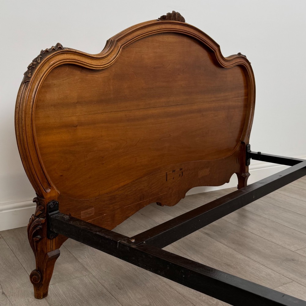A 19th-century French walnut double bed featuring a carved crest headboard, matching footboard with parquetry panels, and short cabriole legs. View VII