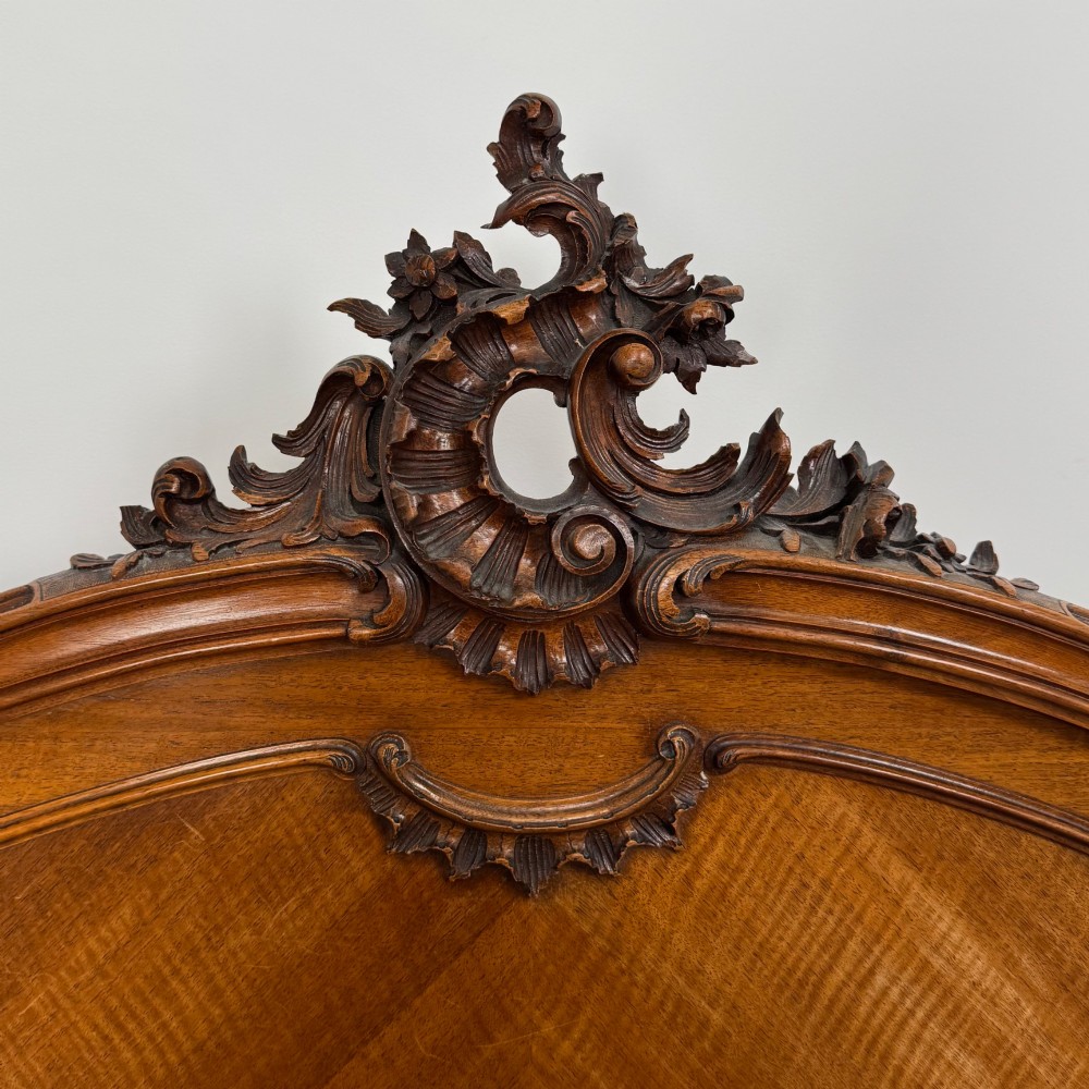 A 19th-century French walnut double bed featuring a carved crest headboard, matching footboard with parquetry panels, and short cabriole legs. View VIII