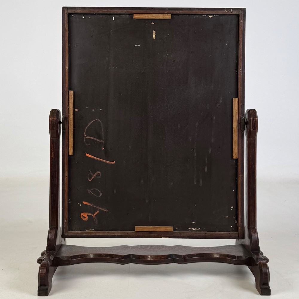 An early 20th-century Arts and Crafts dark oak dressing table mirror set on a shaped base with a swivel frame. View VII
