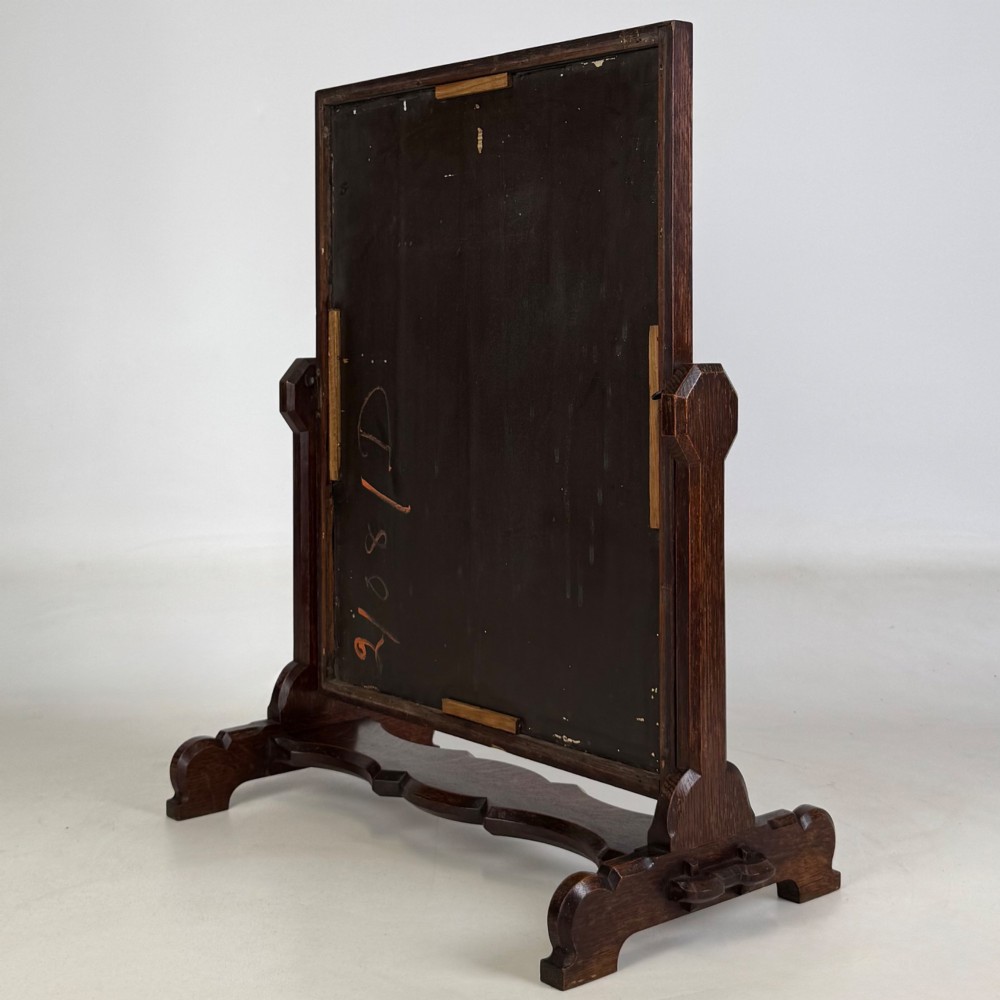An early 20th-century Arts and Crafts dark oak dressing table mirror set on a shaped base with a swivel frame. View VIII