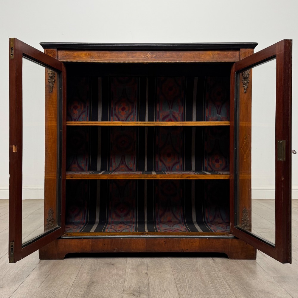 A 19th-century Victorian burr walnut pier cabinet featuring two glass panel doors, brass mounts, marquetry inlay, and a plinth base. View II