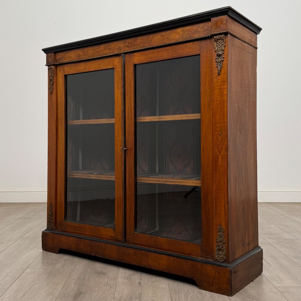 A 19th-century Victorian burr walnut pier cabinet featuring two glass panel doors, brass mounts, marquetry inlay, and a plinth base. View III
