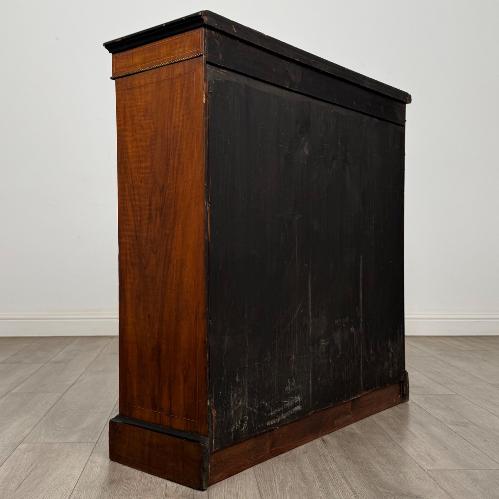 A 19th-century Victorian burr walnut pier cabinet featuring two glass panel doors, brass mounts, marquetry inlay, and a plinth base. View V