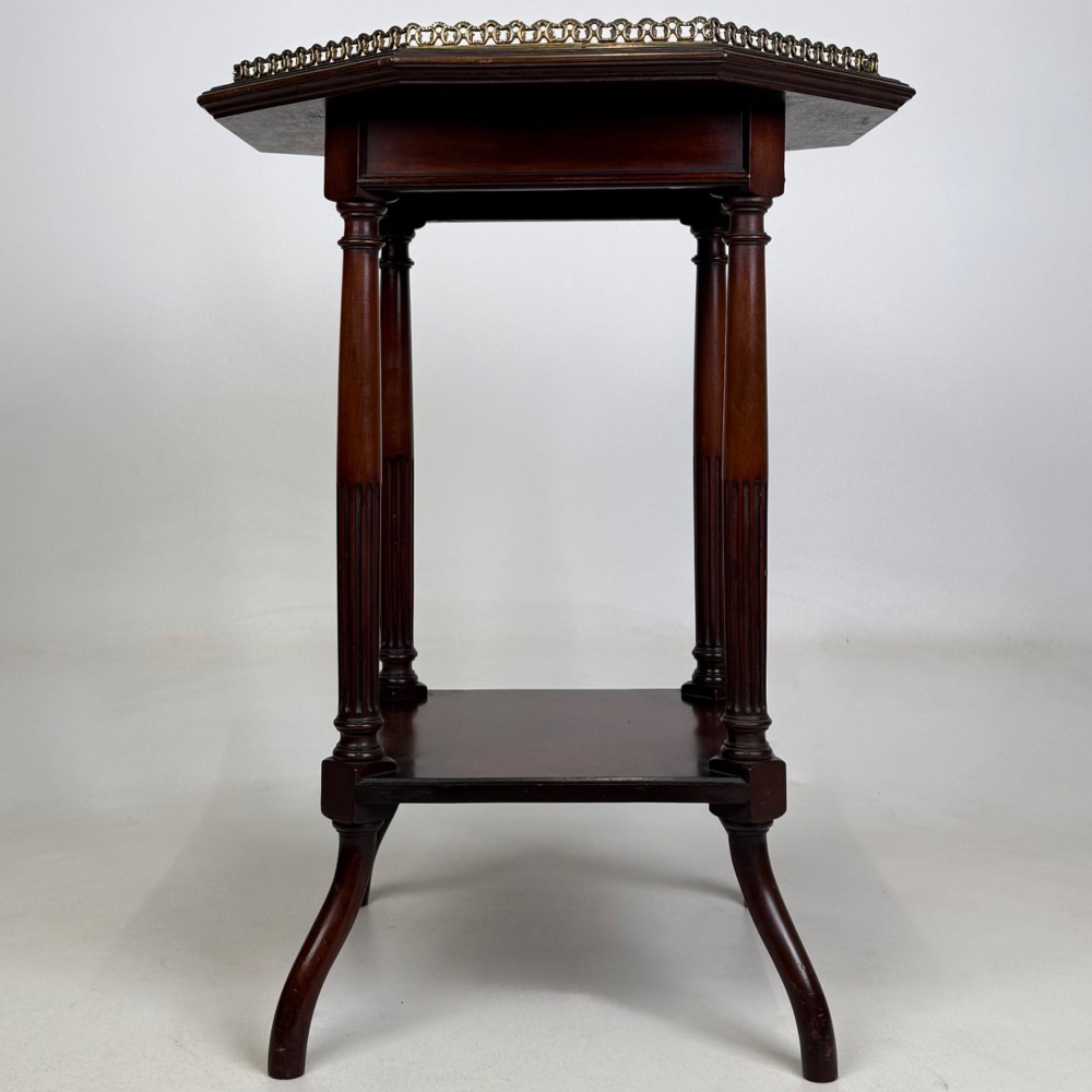 A 19th-century mahogany octagonal side table featuring a brass gallery rail, fluted turned legs, an undertier shelf, and splayed feet. View IX