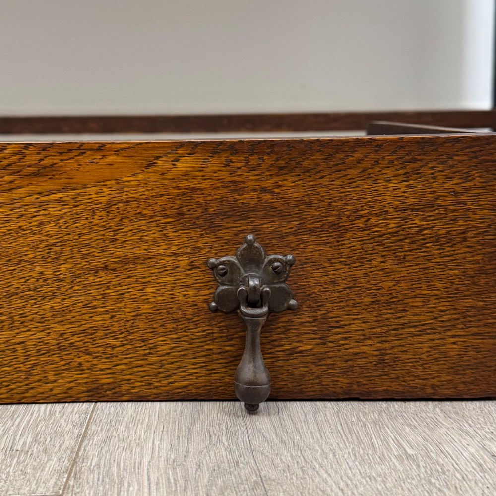 An early 20th-century dark oak Welsh dresser featuring a three-tier open plate rack mounted on a base cabinet with two drawers, geometric panel doors, and barley twist legs. View XII