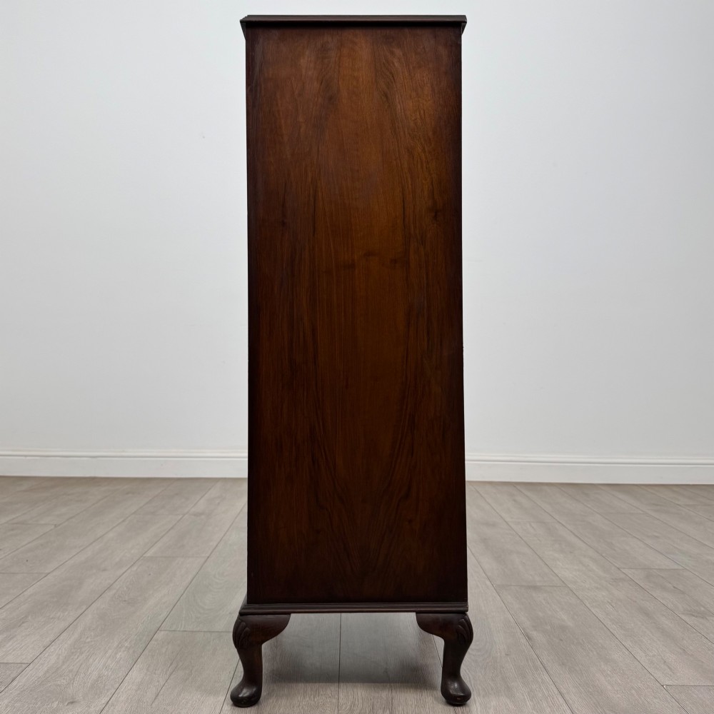 A tall, narrow dark brown burr walnut chest of drawers featuring brass handles and carved cabriole legs. View III